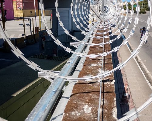 Detalhe em perspectiva de concertina galvanizada instalada para proteção de perímetro.